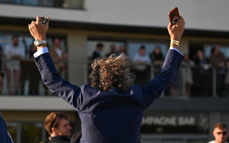 A gentleman celebrating with his arms in the air at Bath Races